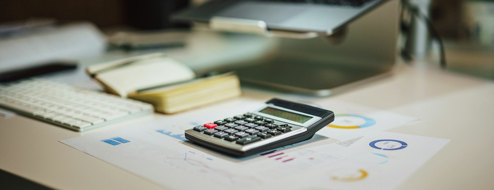 a calculator sitting on top of a table next to a laptop